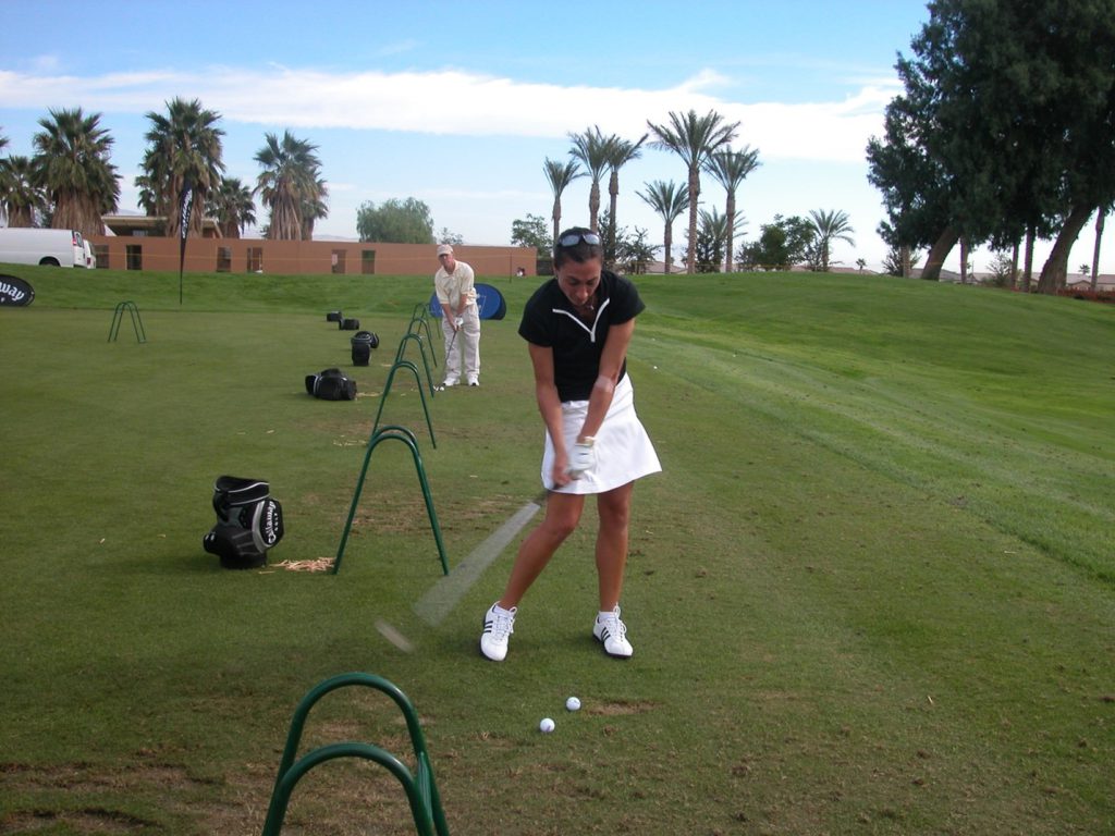 woman golfer hitting balls on the driving range